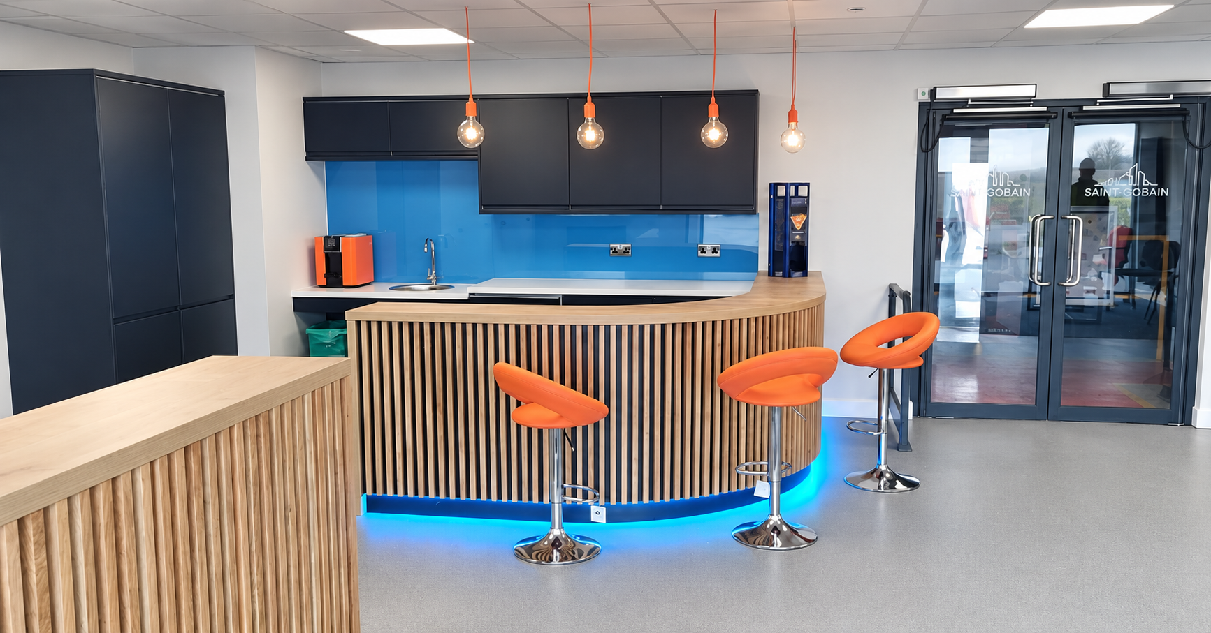 Pendant lights and blue LED lighting installed in a commercial kitchenette by Brooke Electrical